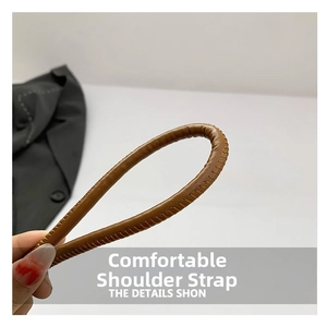Detail of a brown leather shoulder strap with litchi texture and precise stitching