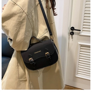 Minimalist black saddle crossbody bag with golden buckles and adjustable strap for women