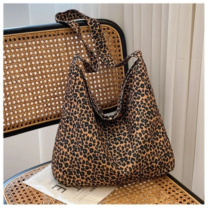 Detail of leopard print canvas tote bag with wide strap on a woven rattan chair