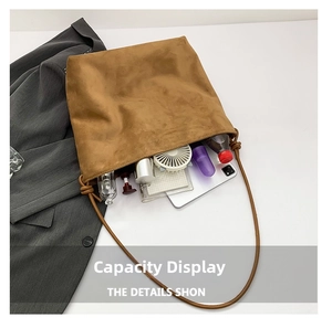 Macro shot showing the spacious interior of the camel suede tote bag with daily items