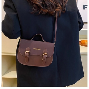 Detail view of brown vintage saddle bag with gold buckles and Fashion Bag logo