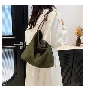 Detail of olive green suede tote bag showing the dark brown leather shoulder strap knot