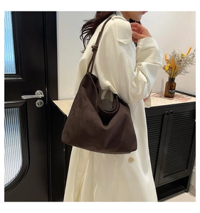 Detail of the unique knot strap design on a dark brown matte suede hobo tote bag