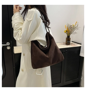 Detail of dark brown canvas tote bag with unique knotted shoulder strap and soft texture