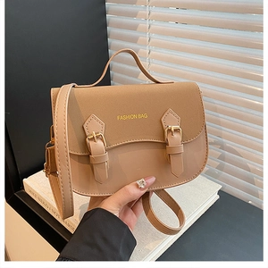 Detail of warm apricot saddle bag featuring suede patchwork and gold fashion lettering