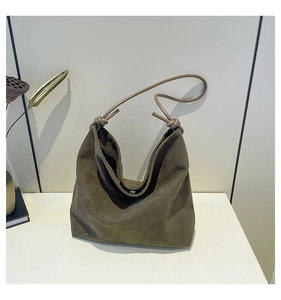 Detail of dark olive green matte suede hobo bag with unique knotted strap design