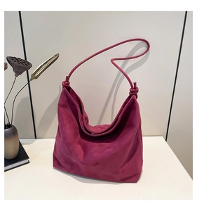 Detailed view of the soft plum suede hobo bag with an elegant knotted thin shoulder strap