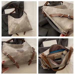 Détail du tissu kaki délavé, des lanières en cuir et de la chaîne argentée du grand sac cabas