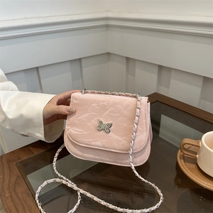 Pink marbled crossbody bag with silver butterfly charm on a wooden table setting