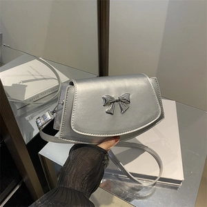 Borsa a tracolla argento con fiocco metallico e design asimmetrico a sella