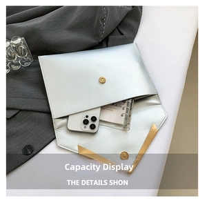 Detail view of the silver envelope clutch interior showing capacity for daily essentials
