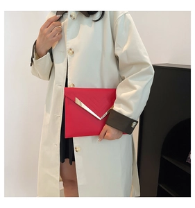Red envelope clutch bag with diagonal stitching and a prominent V-shaped gold metal trim