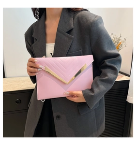 Close-up of pink envelope clutch featuring a gold V-metal bar and twill stitching detail