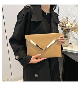 Detail of khaki envelope clutch featuring V-shaped gold metal trim and quilted stitching
