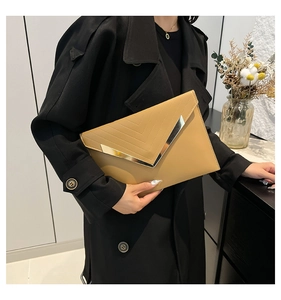 Detail of khaki envelope clutch featuring V-shaped gold metal trim and stitching