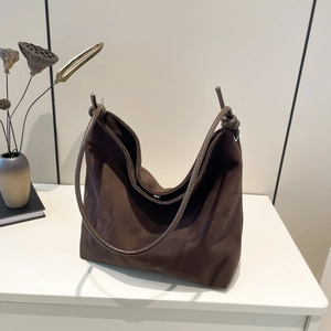 Large dark brown frosted hobo shoulder bag for women in a minimalist scene with dried lotus