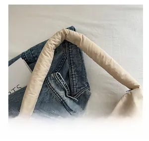 Dettaglio della comoda tracolla imbottita beige della borsa tote dallo stile minimal