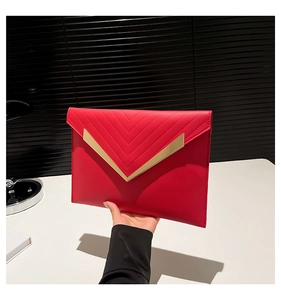 Detail of red envelope clutch with V-shaped quilting and golden metal buckle