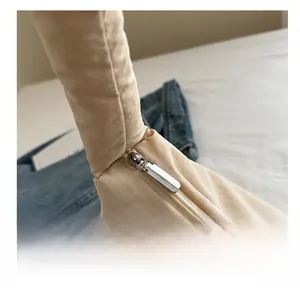Dettaglio della cerniera argento liscia e del tessuto in nylon trapuntato beige