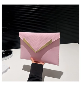 Detail of pink envelope clutch featuring chevron quilting and gold V-shaped metal trim