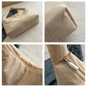 Dettaglio borsa a tracolla in nylon beige con zip in metallo e trama del tessuto morbido