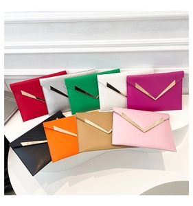 Detail view of multi-color envelope clutch bags with V-shaped gold trim and stitching