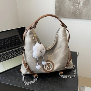 Large capacity vintage canvas hobo bag with leather trim and silver chain on desk