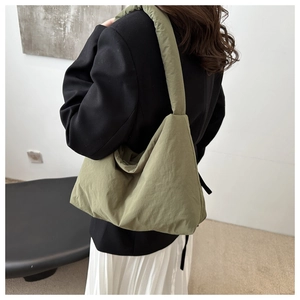 Vue détaillée du sac cabas matelassé vert olive montrant la texture du nylon sur le mannequin