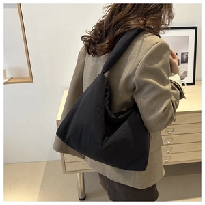 Gros plan d'un sac cabas en nylon noir rembourré avec un design élégant à plis bouffants