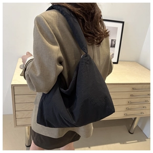 Borsa hobo nera minimalista in nylon di grandi dimensioni mostrata in un interno