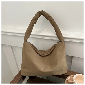 Gros plan sur un sac à bandoulière en nylon marron rembourré avec texture bouffante