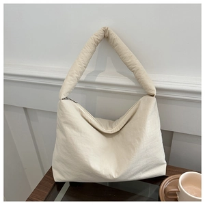 Détail macro du sac cabas matelassé en nylon crème avec texture de tissu doux