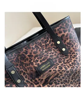 Detail der Leopard-Tragetasche mit schwarzen Ledergriffen und Metallnieten