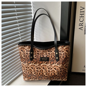Detaillierte Nahaufnahme der Leopard-Tasche mit schwarzen Griffen und Metallnieten-Details