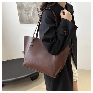 Deep coffee large capacity tote bag shown on a model with minimalist commuter style
