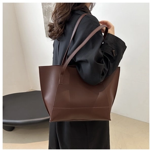 Side view of the large dark brown tote bag being worn on a shoulder for daily commute