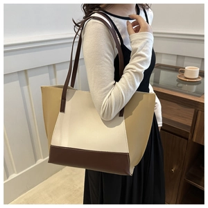 Detailed view of women's large tricolor leather tote bag worn as a chic shoulder bag