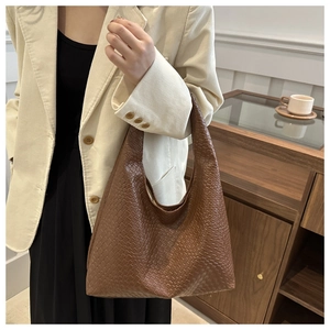 Detail of coffee brown woven texture hobo bag paired with beige corduroy blazer