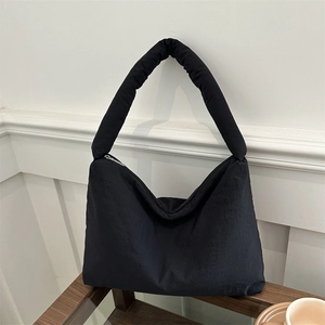 Sac fourre-tout noir en nylon matelassé avec bandoulière rembourrée sur support