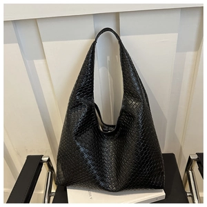 Close-up of black woven leather hobo bag featuring intricate craftsmanship and texture