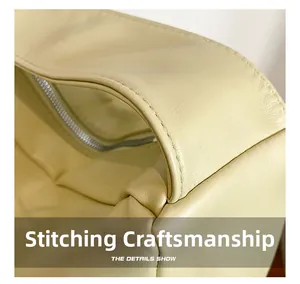Close-up of precise stitching craftsmanship on light yellow faux leather tote bag