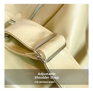 Detail view of the adjustable leather shoulder strap with silver metal buckle on a tote bag