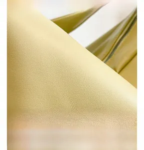 Close-up of yellow leather shoulder bag showing detailed lychee texture and stitching