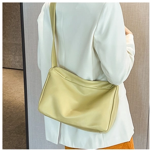 Vista laterale di una borsa tote minimalista verde chiaro con pieghe in pelle morbida