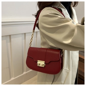 Detail of red croc-embossed shoulder bag with gold square buckle and chain strap