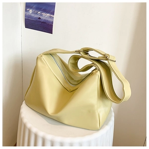 Detail of soft pale yellow leather tote with silver zipper and adjustable buckle strap