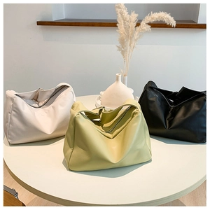 Detailed display of three large capacity soft leather tote bags in cream green and black