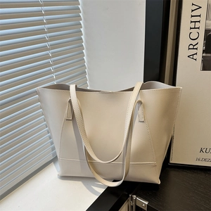 Minimalist large-capacity cream tote bag in matte faux leather for chic urban commuting