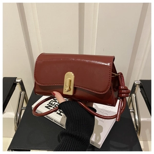 Deep red patent leather baguette bag featuring a gold metal buckle and knotted strap detail