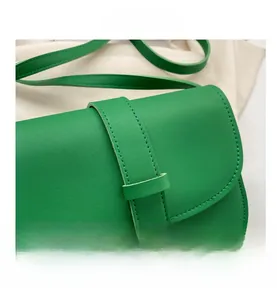 Detail of bright green leather crossbody bag with minimalist flap and fine stitching